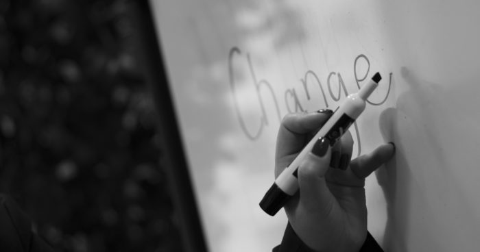 The word "change" written on a whiteboard with a handheld marker